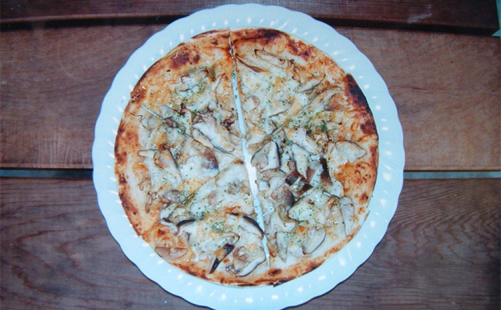 キノコたっぷりの自慢のピザ